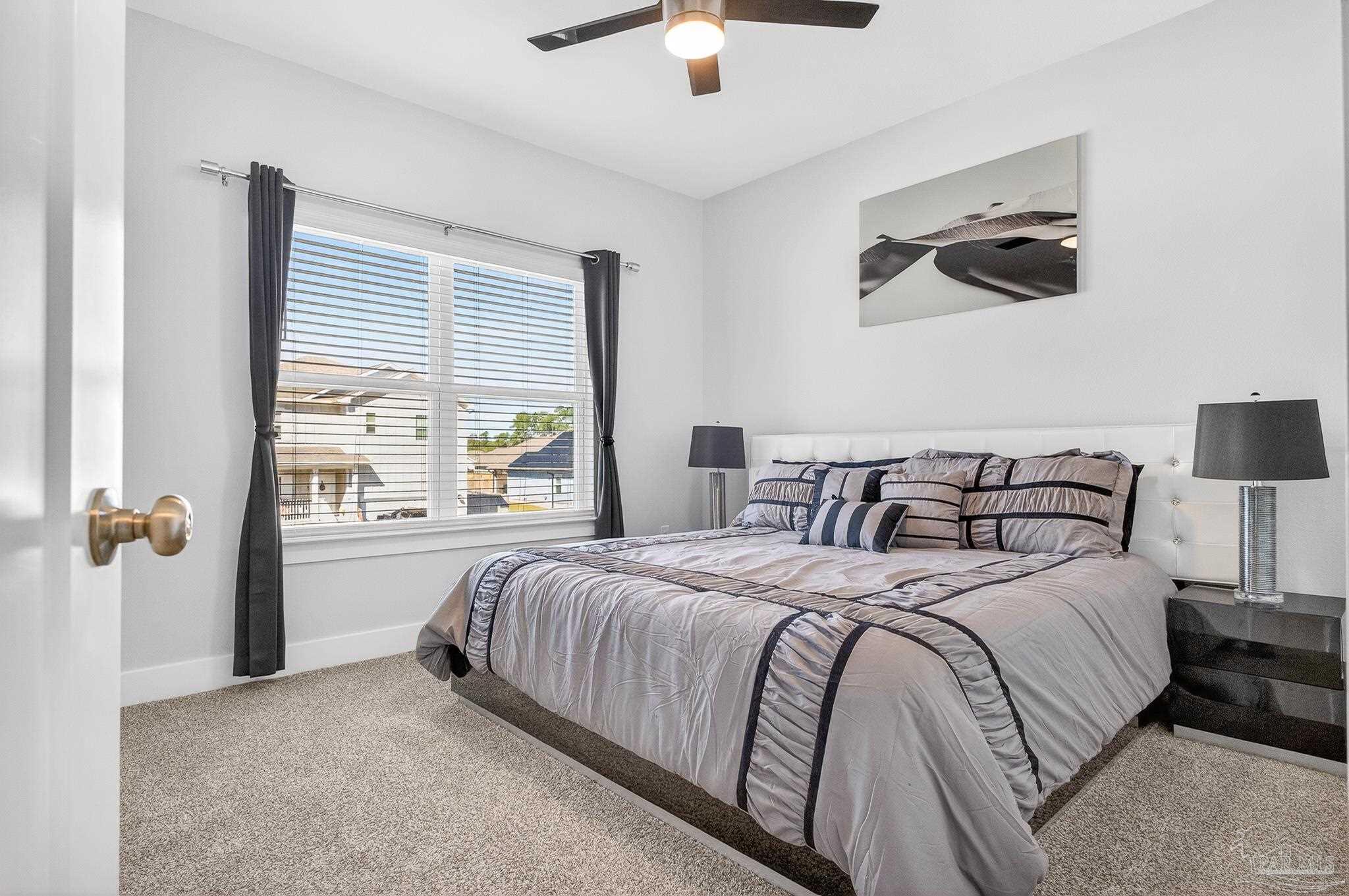 6076 Rutherford Loop Pensacola, FL 32526 - Photo 53 of 67 a bedroom with a large bed and a chandelier