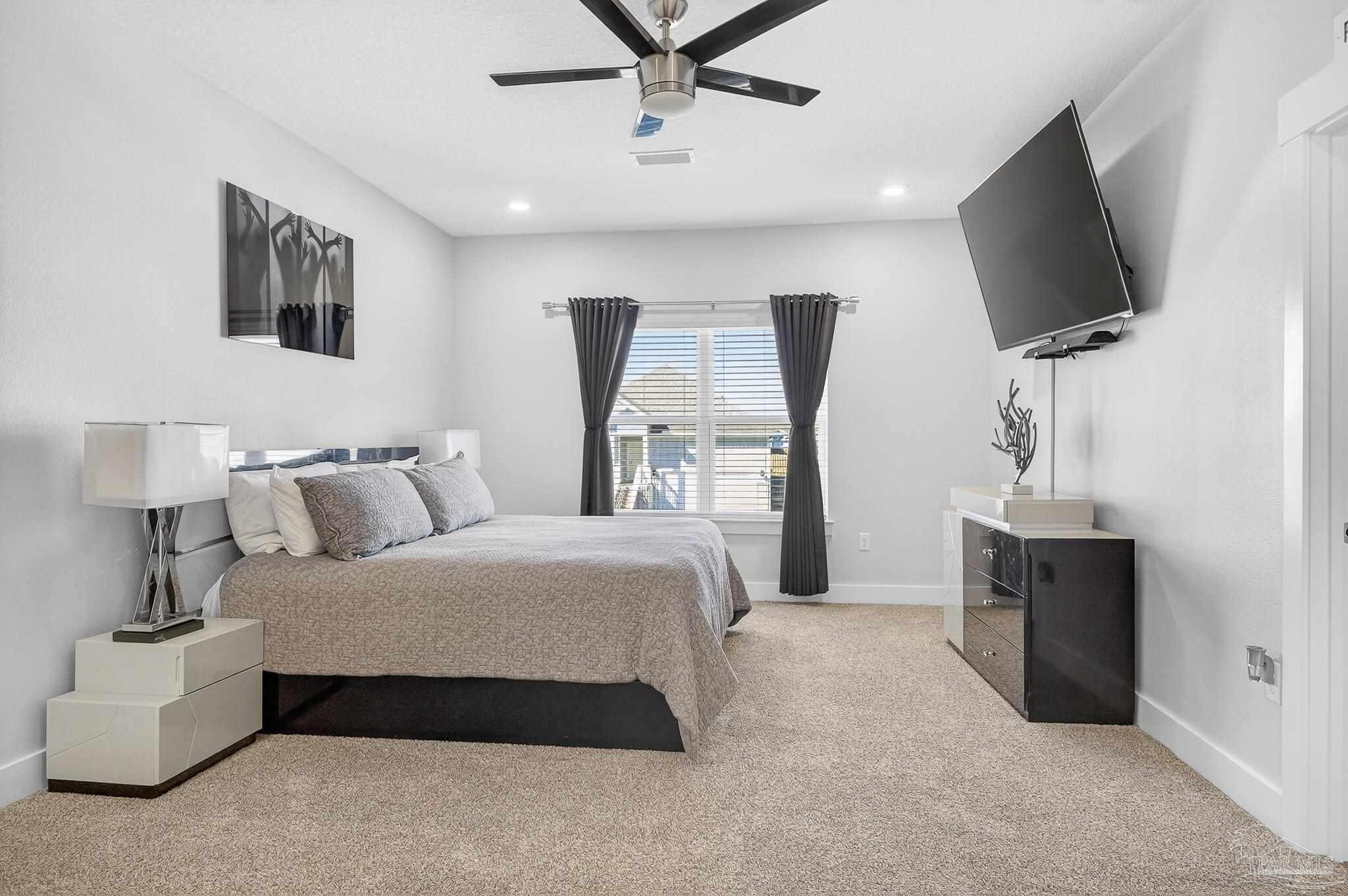 6076 Rutherford Loop Pensacola, FL 32526 - Photo 60 of 67 a spacious bedroom with a bed and a flat screen television