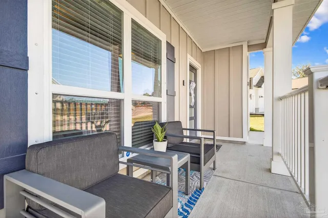 a living room with furniture a wooden floor and a large window