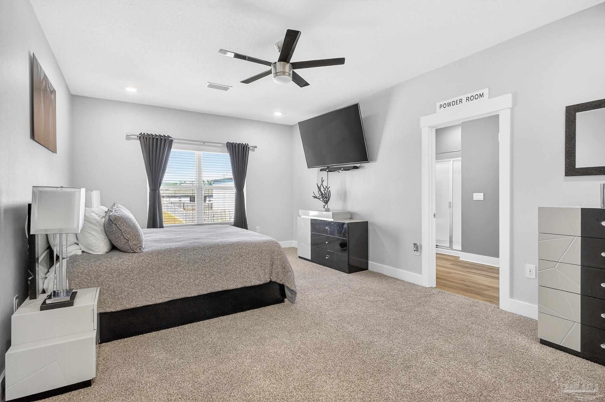 6076 Rutherford Loop Pensacola, FL 32526 - Photo 61 of 67 a spacious bedroom with a bed and a flat screen tv