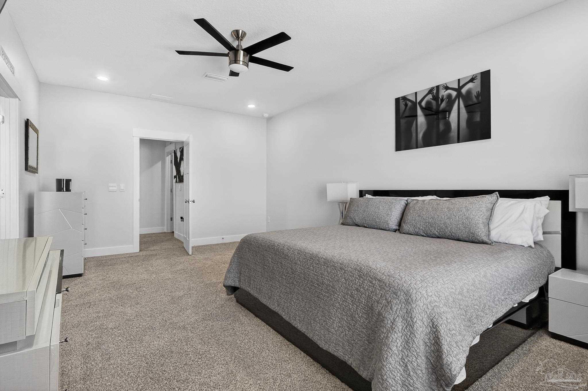 6076 Rutherford Loop Pensacola, FL 32526 - Photo 64 of 67 a spacious bedroom with a bed and a ceiling fan
