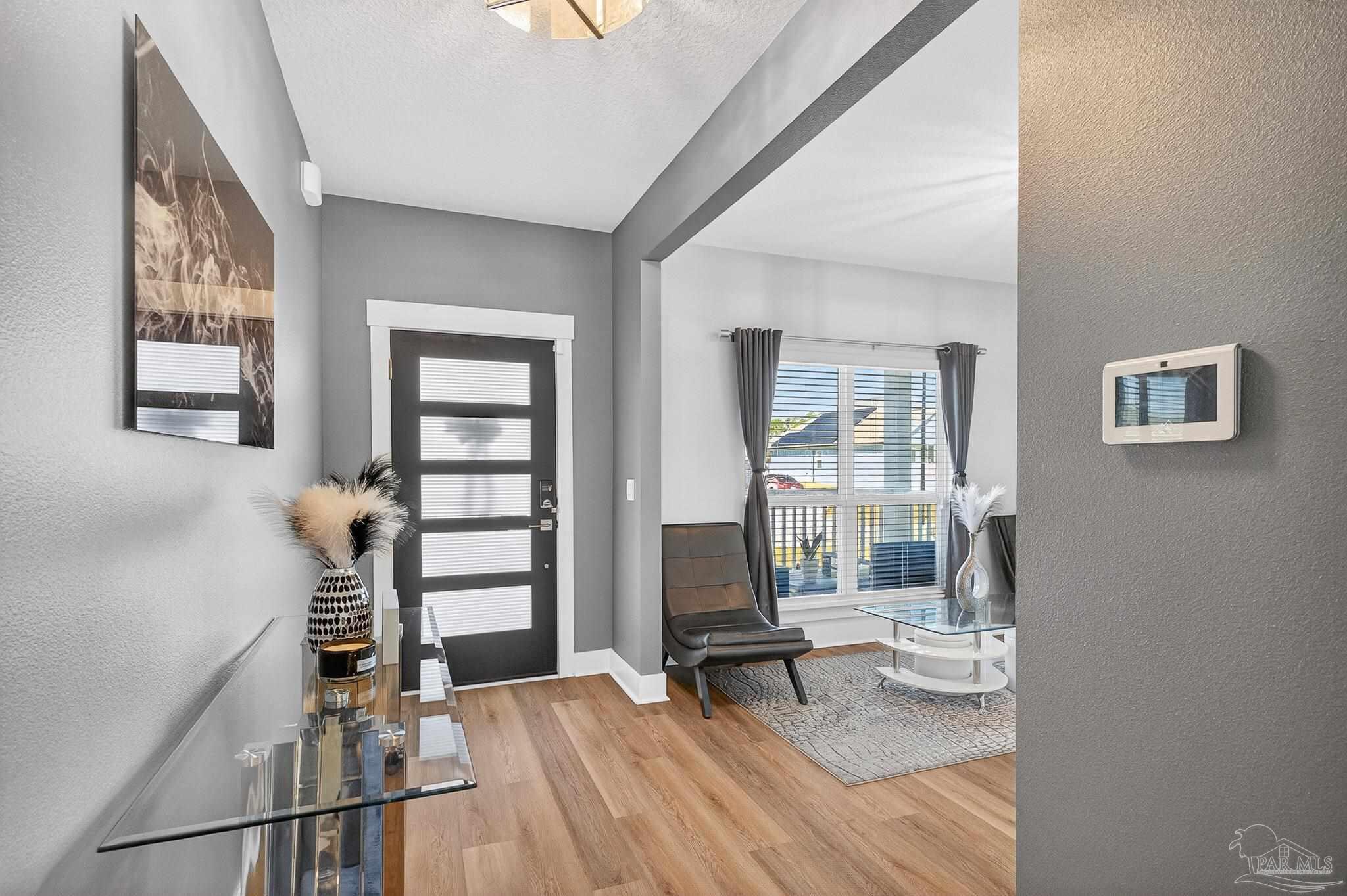 6076 Rutherford Loop Pensacola, FL 32526 - Photo 8 of 67 a living room with furniture a wooden floor and a large window