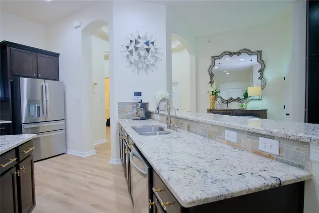 a kitchen with granite countertop kitchen island a counter space and stainless steel appliances