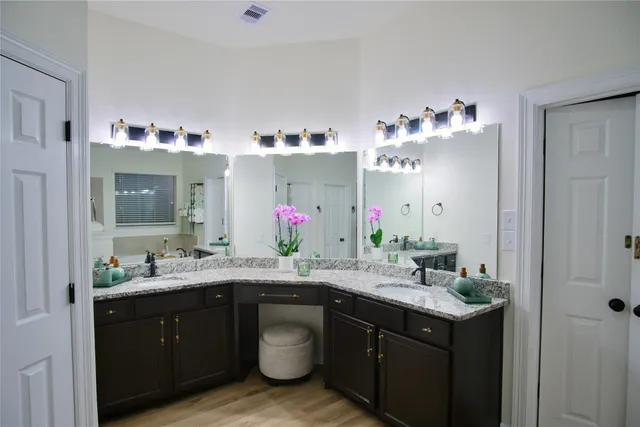 a bathroom with a granite countertop sink and a mirror