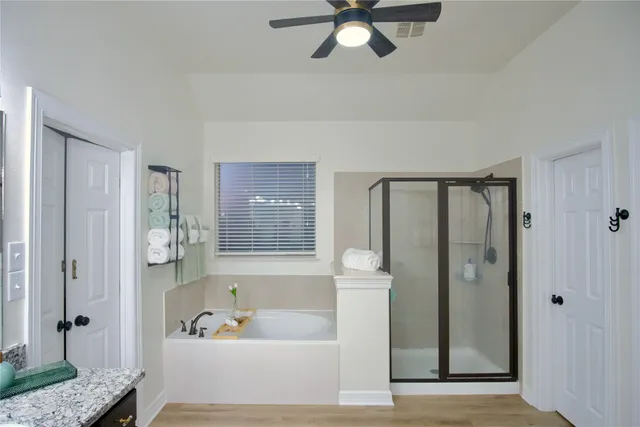 a bathroom with a tub shower and window