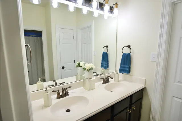 a bathroom with double sink and a mirror