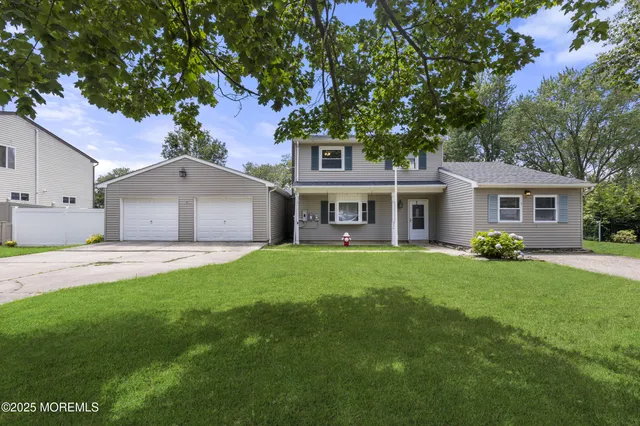a front view of a house with a yard and trees