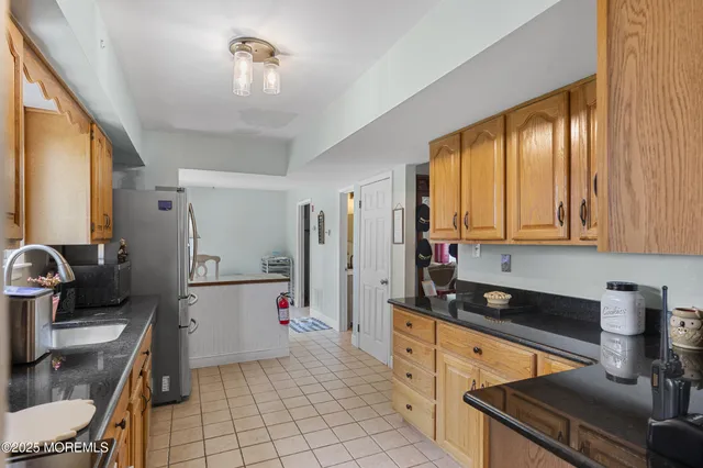 a kitchen with a refrigerator and a stove top oven