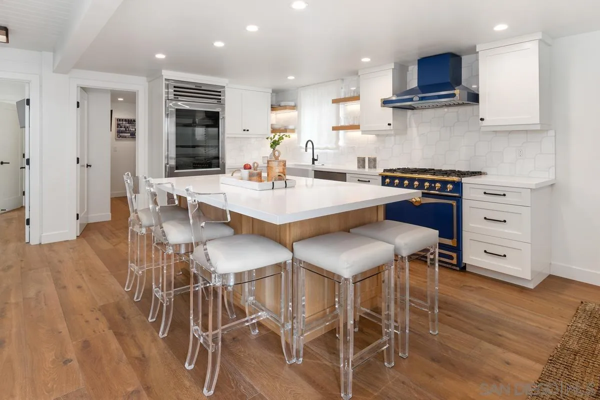 123 Jasper Street, Unit 29 Encinitas, CA 92024 - Photo 3 of 19 a kitchen with stainless steel appliances kitchen island granite countertop a wooden table and chairs