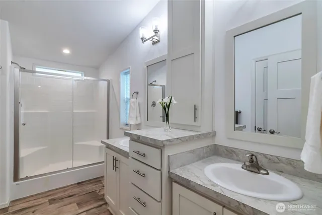 a bathroom with a shower sink and mirror