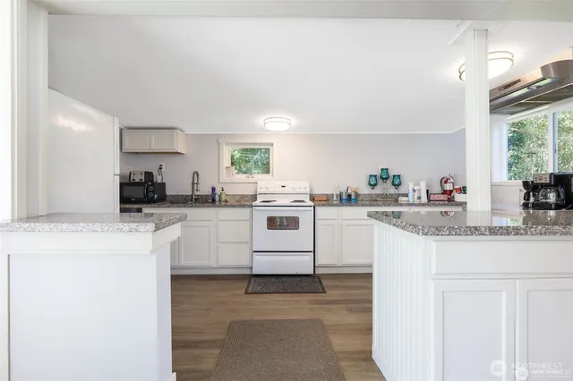 a kitchen with granite countertop white cabinets and white appliances