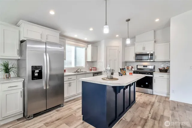 a kitchen with a sink stainless steel appliances and white cabinets