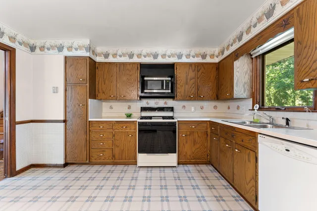 a kitchen with a refrigerator sink and cabinets