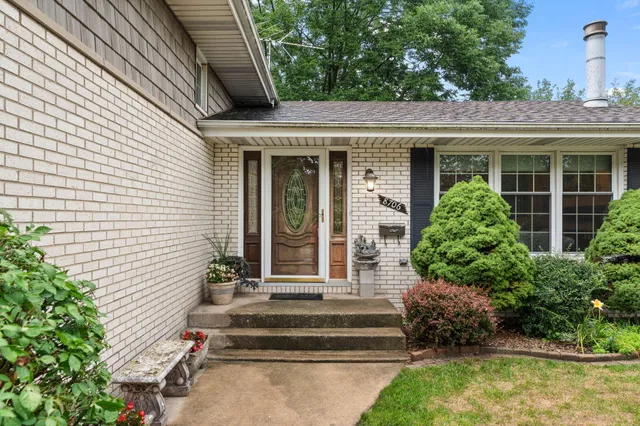a view of a house with potted plants and a table and chairs