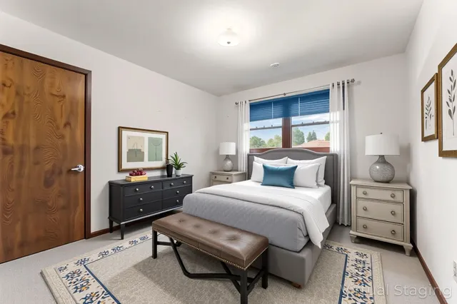 a bedroom with a bed a table and painting on the wall