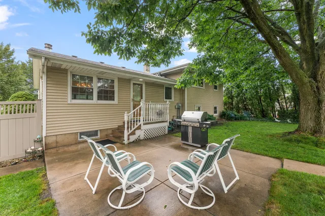 a view of a chair and table in backyard of the house