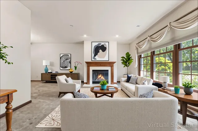 a living room with furniture large window and a fireplace