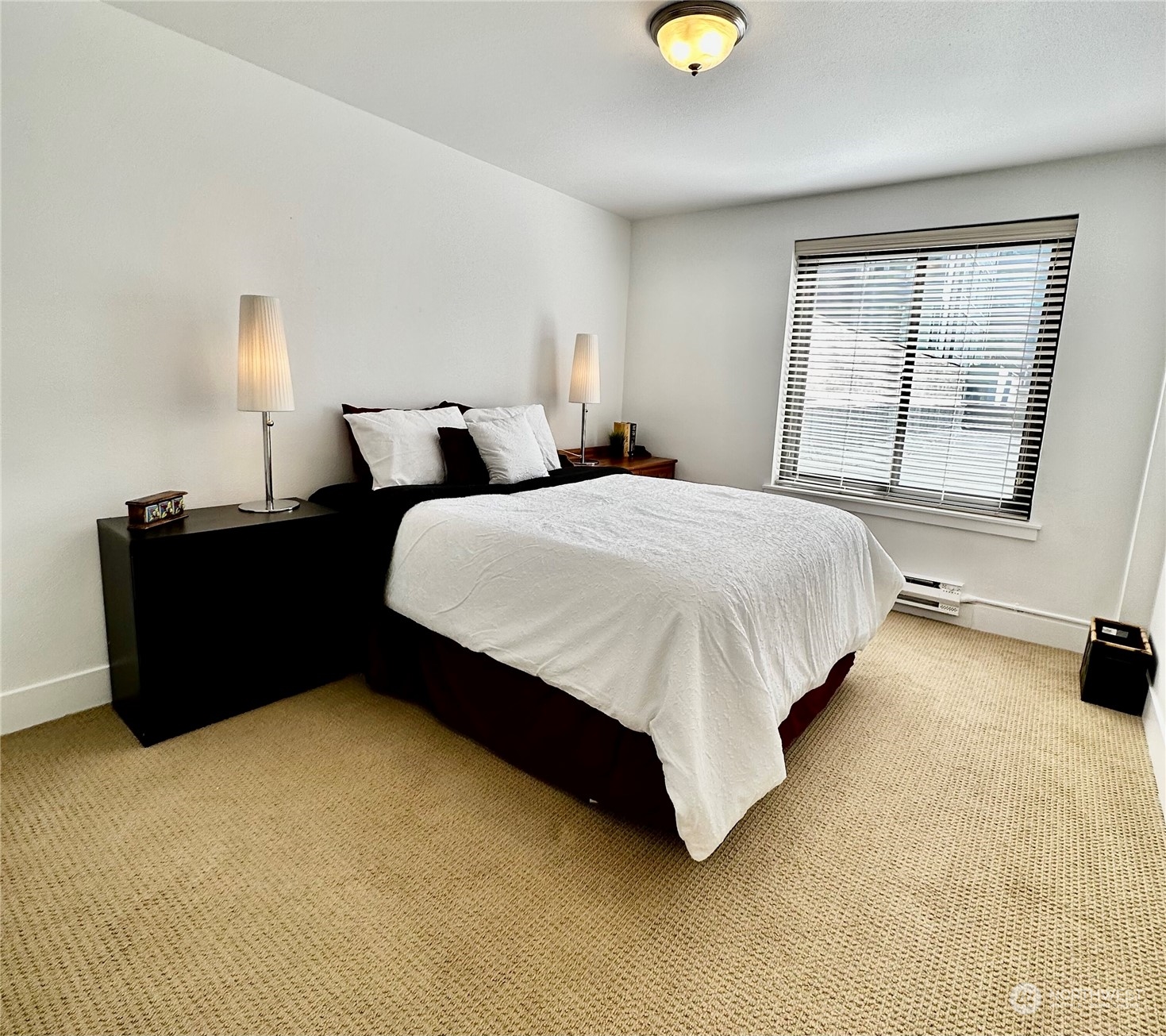 1105 Spring Street, Unit 203 Seattle, WA 98104 - Photo 8 of 21 a spacious bedroom with a bed and window