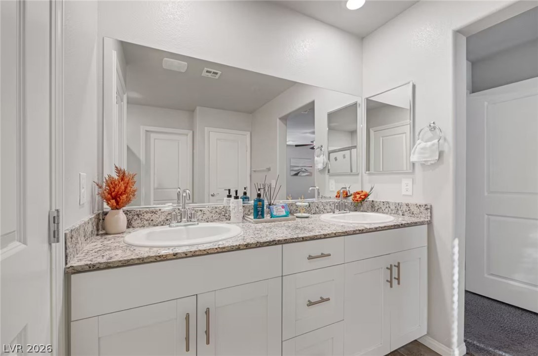 8244 Selenite Street Las Vegas, NV 89113 - Photo 12 of 16 This spacious bathroom offers dual sinks and ample counter space for a comfortable daily routine.
