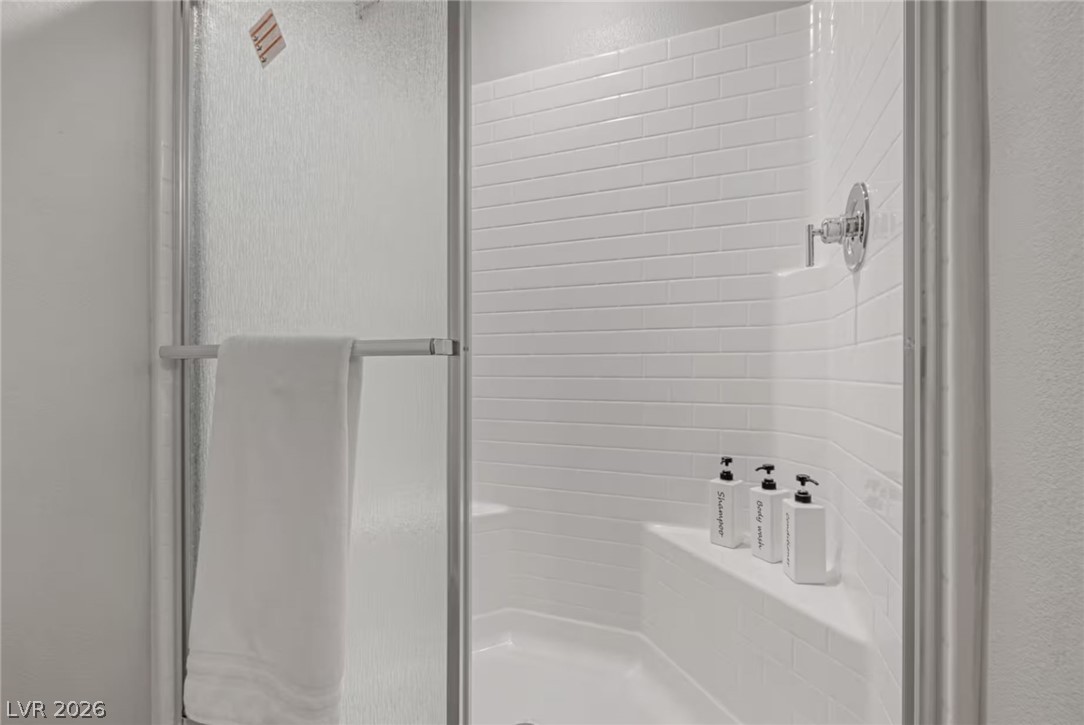 8244 Selenite Street Las Vegas, NV 89113 - Photo 14 of 16 This sleek shower features subway tile and a built-in bench for comfort and style.
