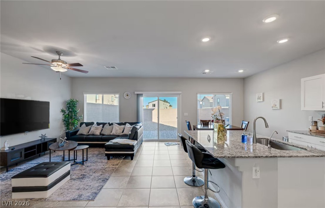 8244 Selenite Street Las Vegas, NV 89113 - Photo 3 of 16 This bright and airy open-concept living area seamlessly connects to the kitchen and outdoor space.