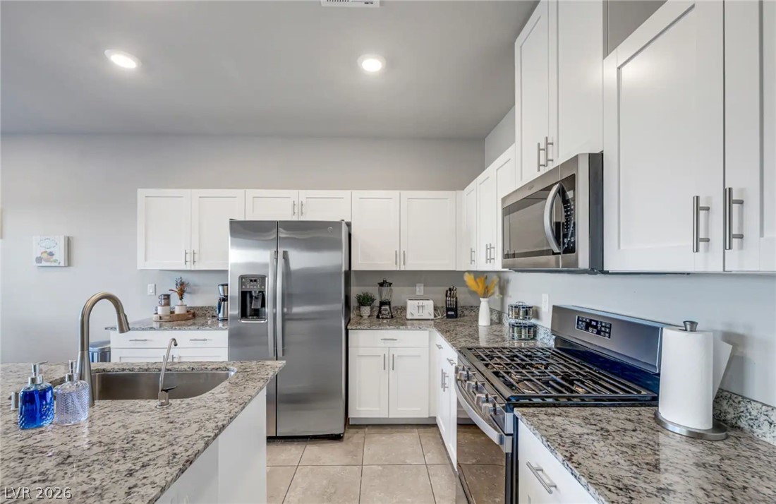8244 Selenite Street Las Vegas, NV 89113 - Photo 4 of 16 This modern kitchen features elegant countertops, stainless steel appliances, and ample cabinet space.