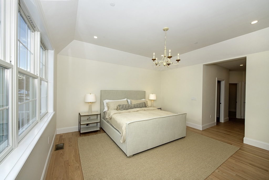 25 Clubview Drive, Unit 25 Andover, MA 01810 - Photo 12 of 19 a spacious bedroom with a bed and a chandelier
