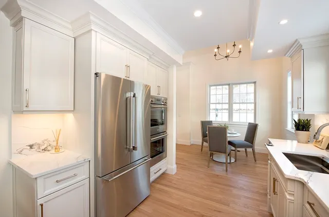 a kitchen with stainless steel appliances granite countertop a refrigerator and a stove top oven