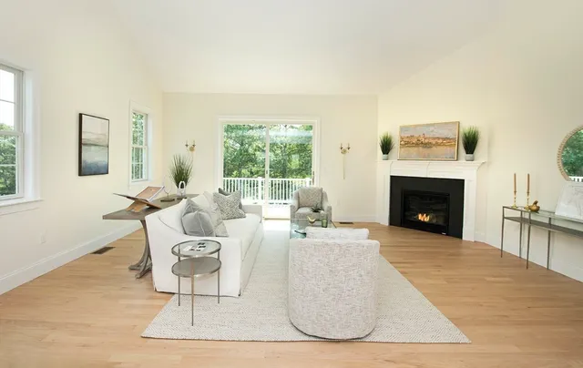 a living room with furniture a large window and a fireplace