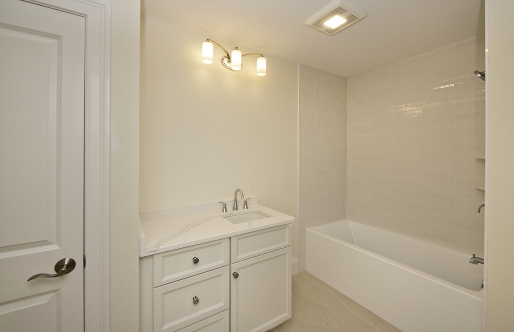 25 Clubview Drive, Unit 25 Andover, MA 01810 - Photo 9 of 19 a bathroom with a tub sink vanity and a mirror