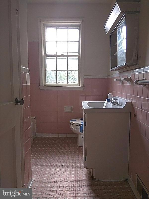 4028 Fallstaff Road Baltimore, MD 21215 - Photo 23 of 28 a bathroom with a sink toilet and mirror