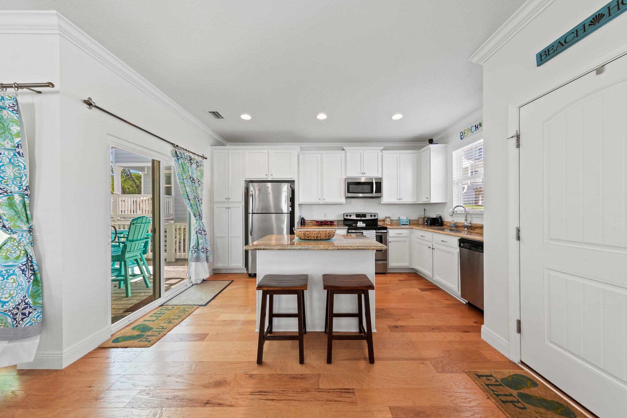 174 Sandpine Loop Inlet Beach, FL 32461 - Photo 14 of 45 a kitchen with stainless steel appliances kitchen island granite countertop a refrigerator a stove a sink a dining table and chairs with wooden floor