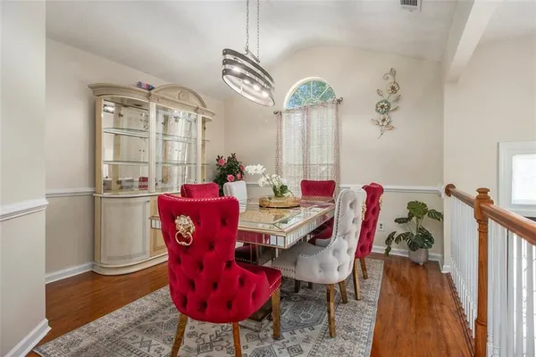 a view of a dining room with furniture a chandelier and wooden floor