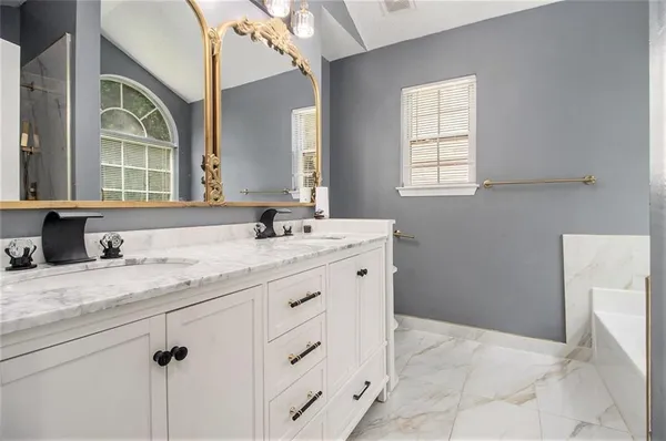 a bathroom with a granite countertop sink a mirror and a bathtub