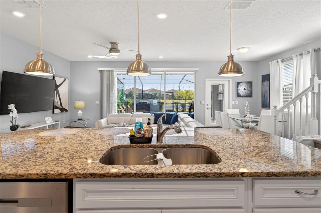 7554 Oak Spring Lane Davenport, FL 33837 - Photo 16 of 74 a kitchen with kitchen island granite countertop a sink and a large window