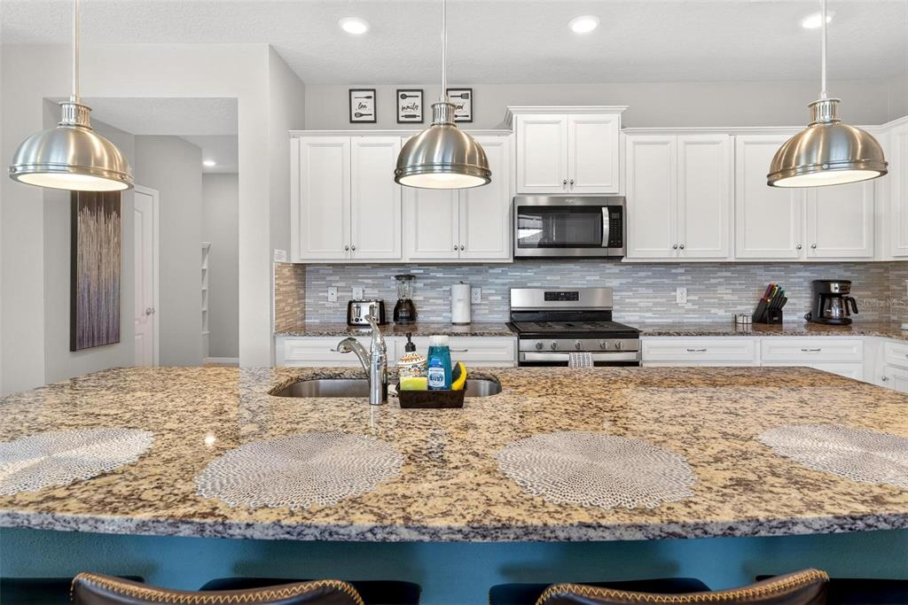 7554 Oak Spring Lane Davenport, FL 33837 - Photo 18 of 74 a kitchen with granite countertop a stove and a sink