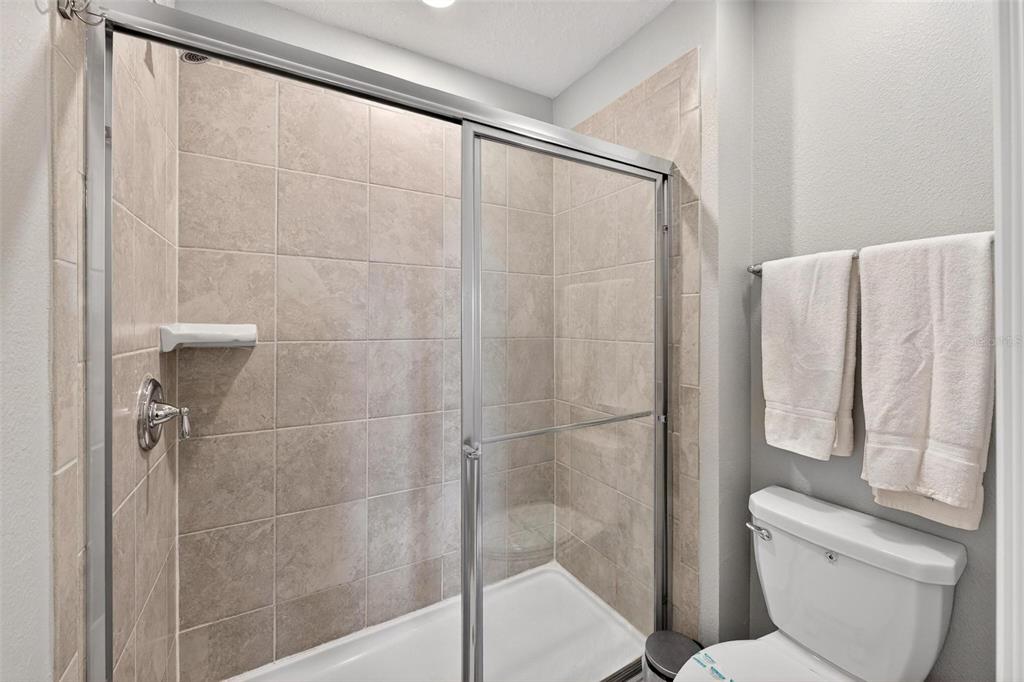 7554 Oak Spring Lane Davenport, FL 33837 - Photo 39 of 74 a bathroom with a shower and a toilet