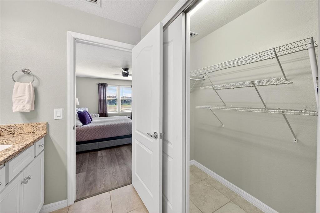 7554 Oak Spring Lane Davenport, FL 33837 - Photo 40 of 74 a bedroom with a bed and a view of bathroom