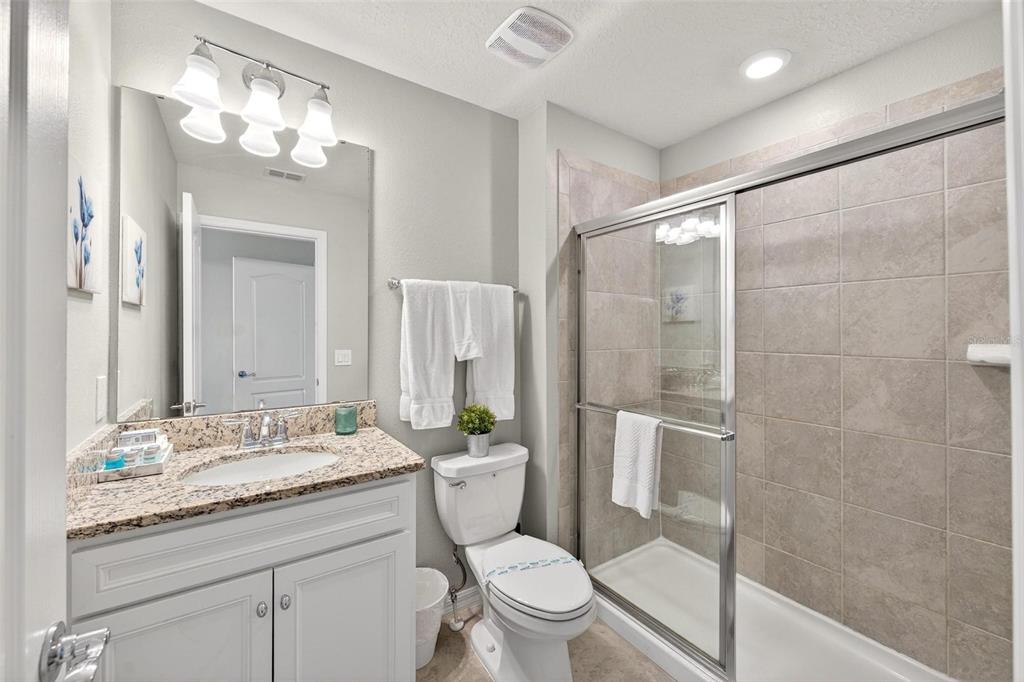 7554 Oak Spring Lane Davenport, FL 33837 - Photo 45 of 74 a bathroom with a granite countertop sink toilet and shower
