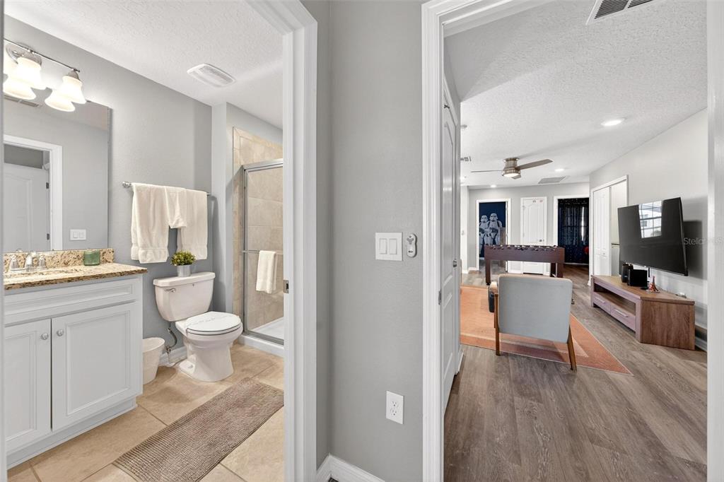 7554 Oak Spring Lane Davenport, FL 33837 - Photo 46 of 74 a bathroom with a toilet a sink and a large mirror