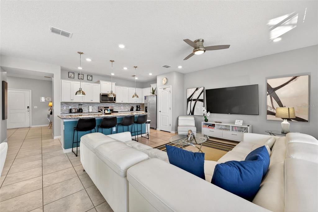 7554 Oak Spring Lane Davenport, FL 33837 - Photo 6 of 74 a living room with furniture kitchen view and a flat screen tv