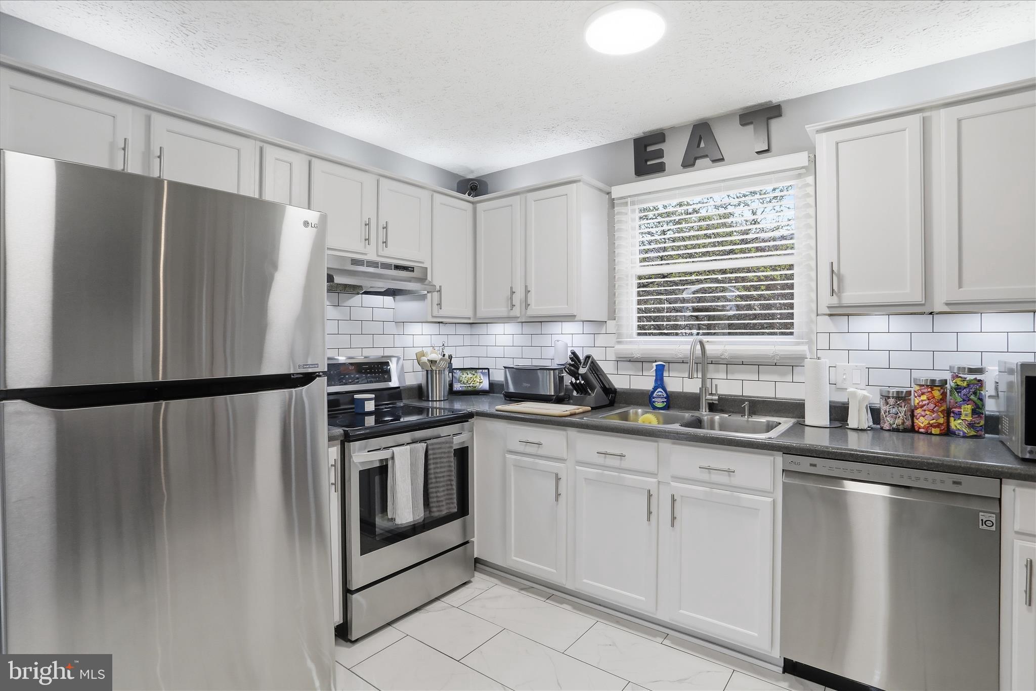 65 South Hummingbird Street Keyser, WV 26726 - Photo 17 of 30 a kitchen with white cabinets white stainless steel appliances and sink