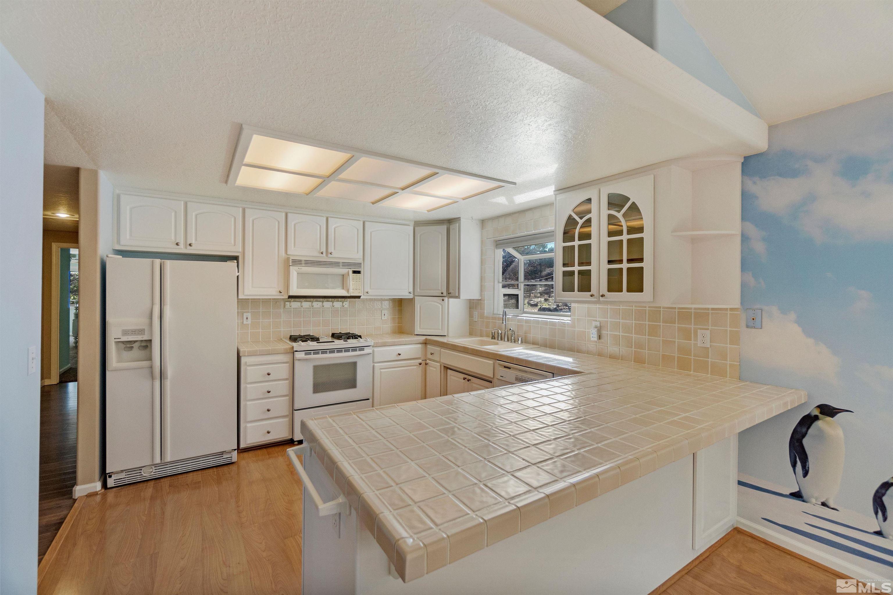 1200 Lampe Road Reno, NV 89511 - Photo 14 of 34 a kitchen with stainless steel appliances granite countertop a sink and a refrigerator