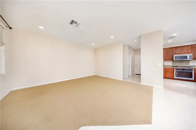 a view of an empty room with a kitchen