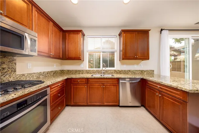a kitchen with stainless steel appliances granite countertop a sink and stove top oven