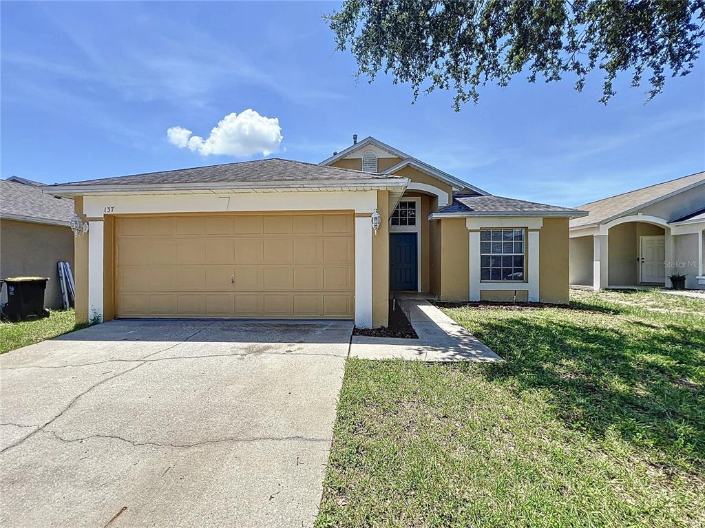 137 Piano Lane Davenport, FL 33896 - Photo 1 of 13 a front view of a house with garden