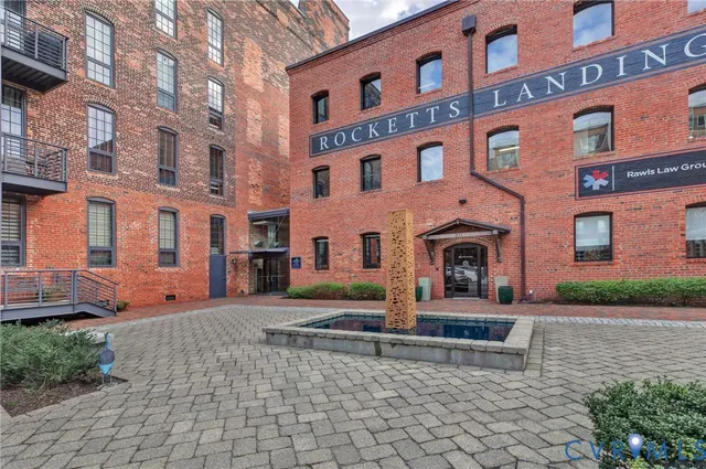 a front view of a building with barbeque and trees