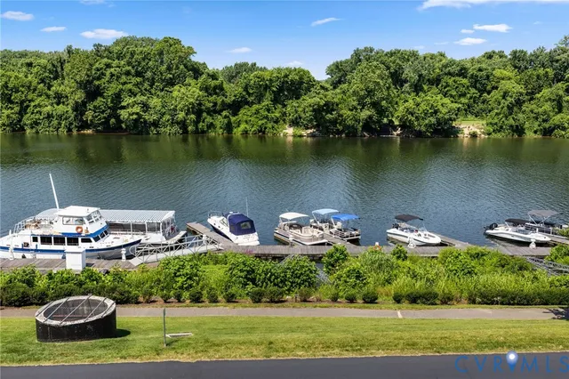 an aerial view of a house with outdoor space lake view and a mountain view in back