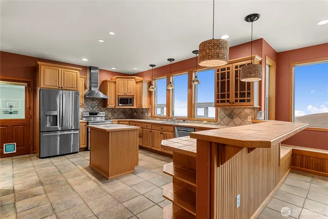 a large kitchen with stainless steel appliances granite countertop a stove and a sink