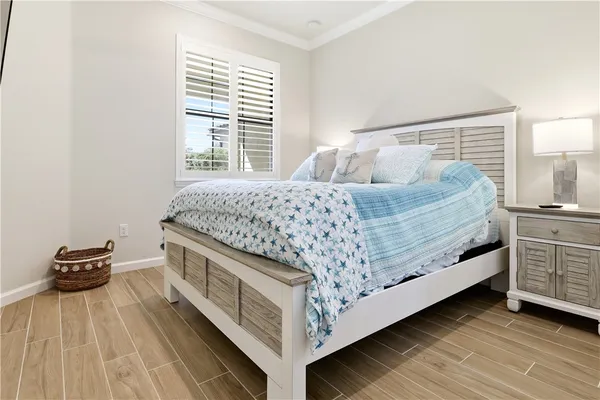 a bed sitting in a bedroom next to a window and a lamp